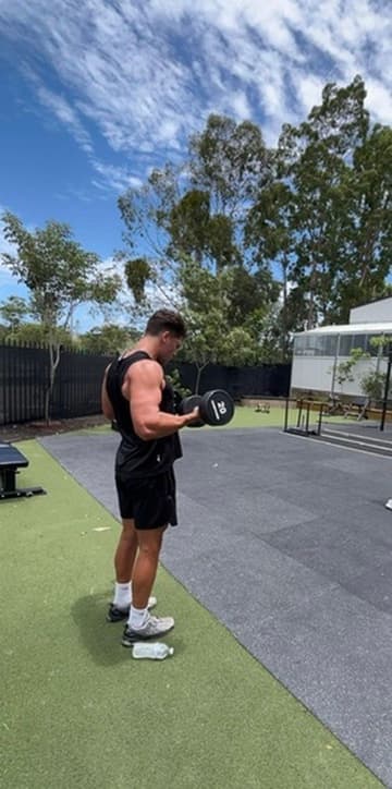Creator training with a dumbbell at the outdoor gym